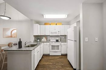 A kitchen with white cabinets and appliances